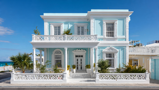 Coastal house with white balcony railings and ocean view windows.