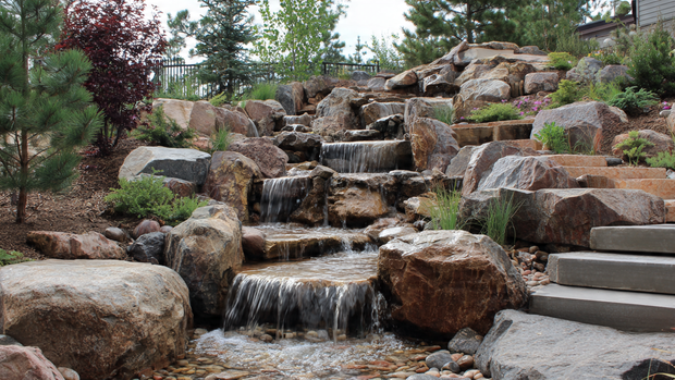 16 Natural Stone Waterfall for Hillside Beauty and Relaxation 7 Tiered hillside waterfall with layered natural stones and flowing water.