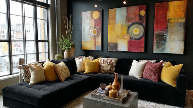 12 Stunning Black Couch Living Room Ideas with Style 5 Black sectional with yellow pillows and colorful abstract wall art in a bright living room.